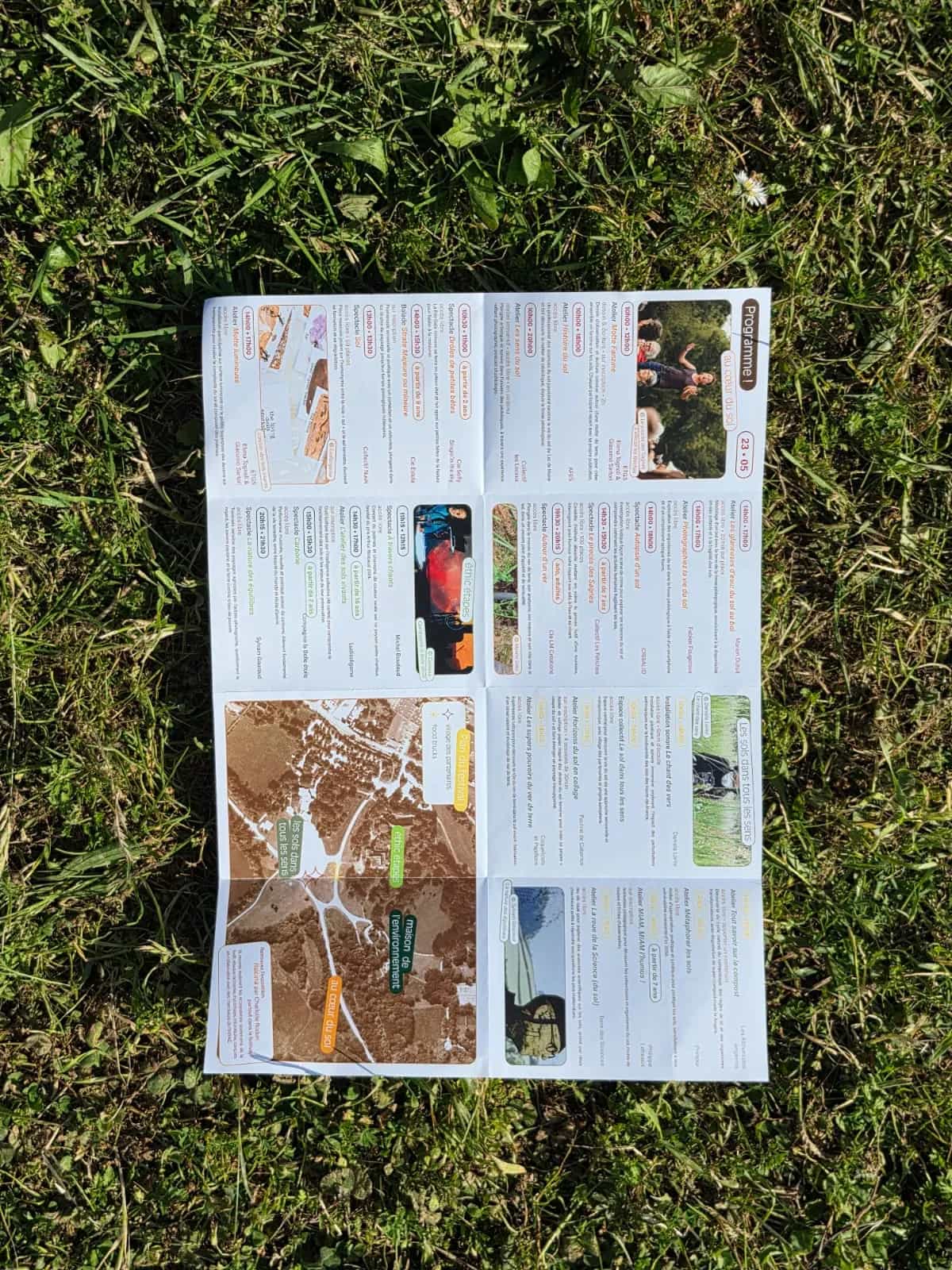 The leaflet fully unfolded on the grass: programme, photographs and map